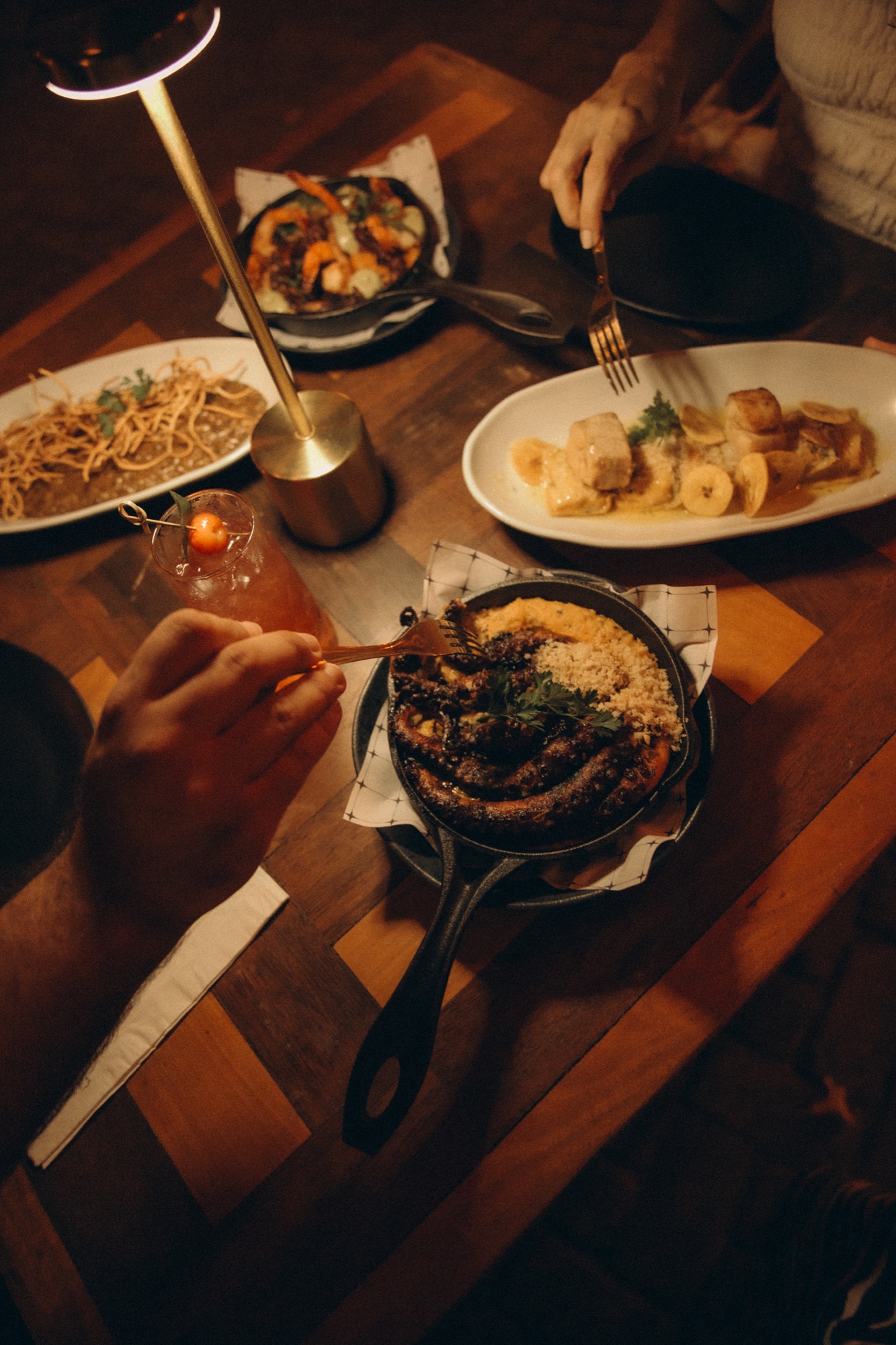 Mesa com pratos e drinks do Nu Gastrobar